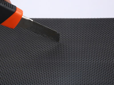 A sharp knife is cutting a piece of security screen, while the screen is firm enough to keep undamaged.